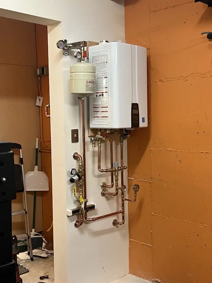 Plumbing technician inspecting water heater connections in Hanceville